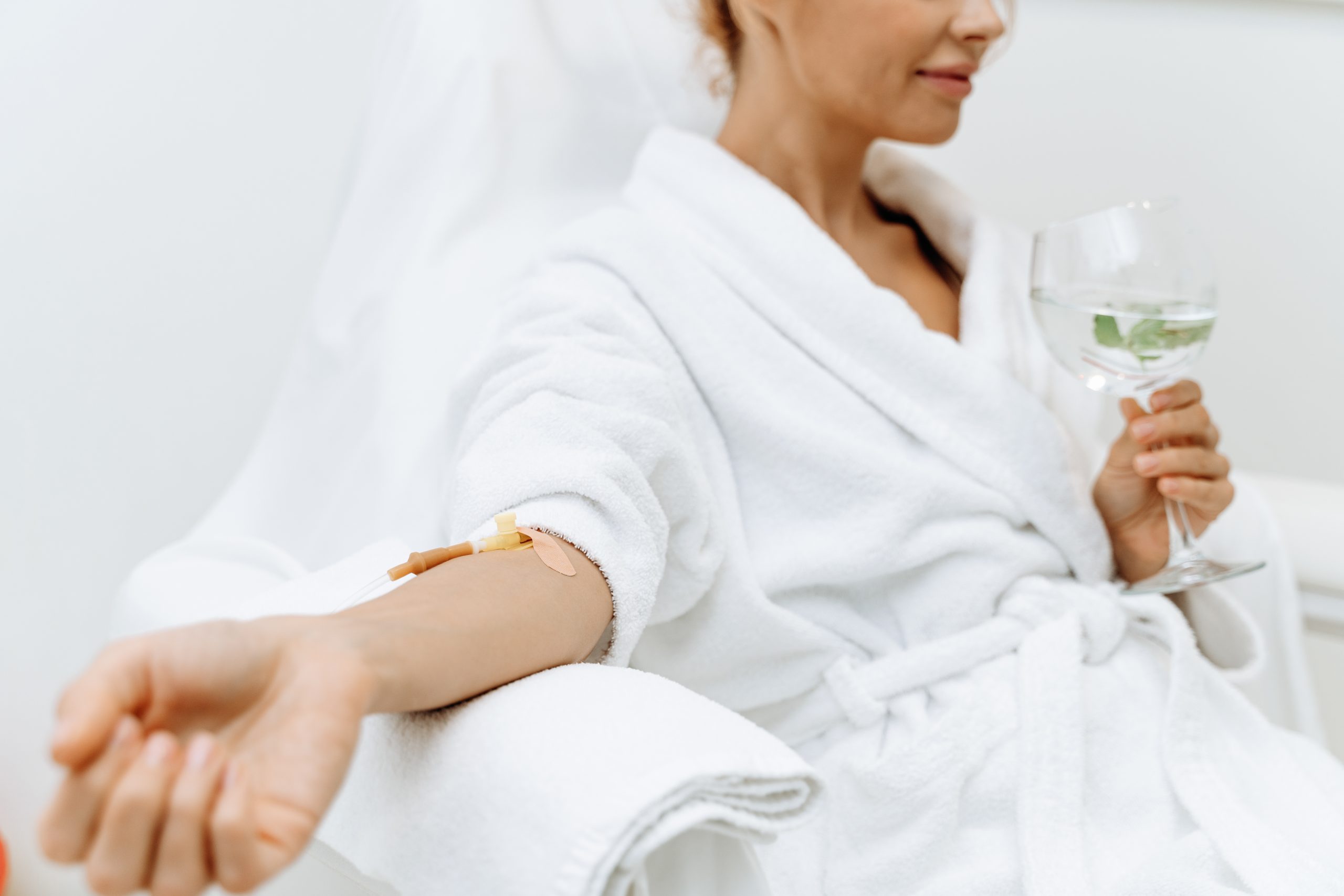 Female Patient sitting with tube and needle during IV infusion.
